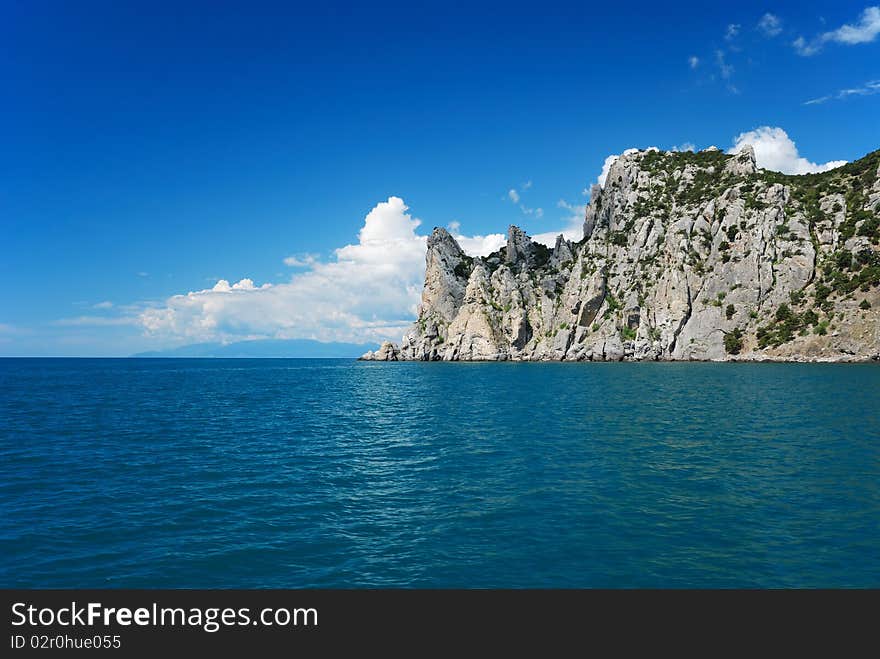 The pointed cape juts far into the Black Sea. It is photographed from the dark blue sea. The pointed cape juts far into the Black Sea. It is photographed from the dark blue sea.