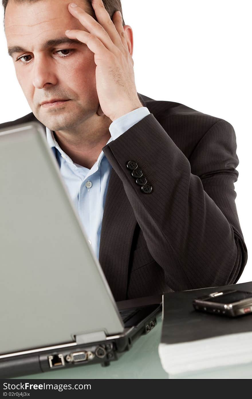 Businessman working on laptop, leaning hand on head thinking. Businessman working on laptop, leaning hand on head thinking