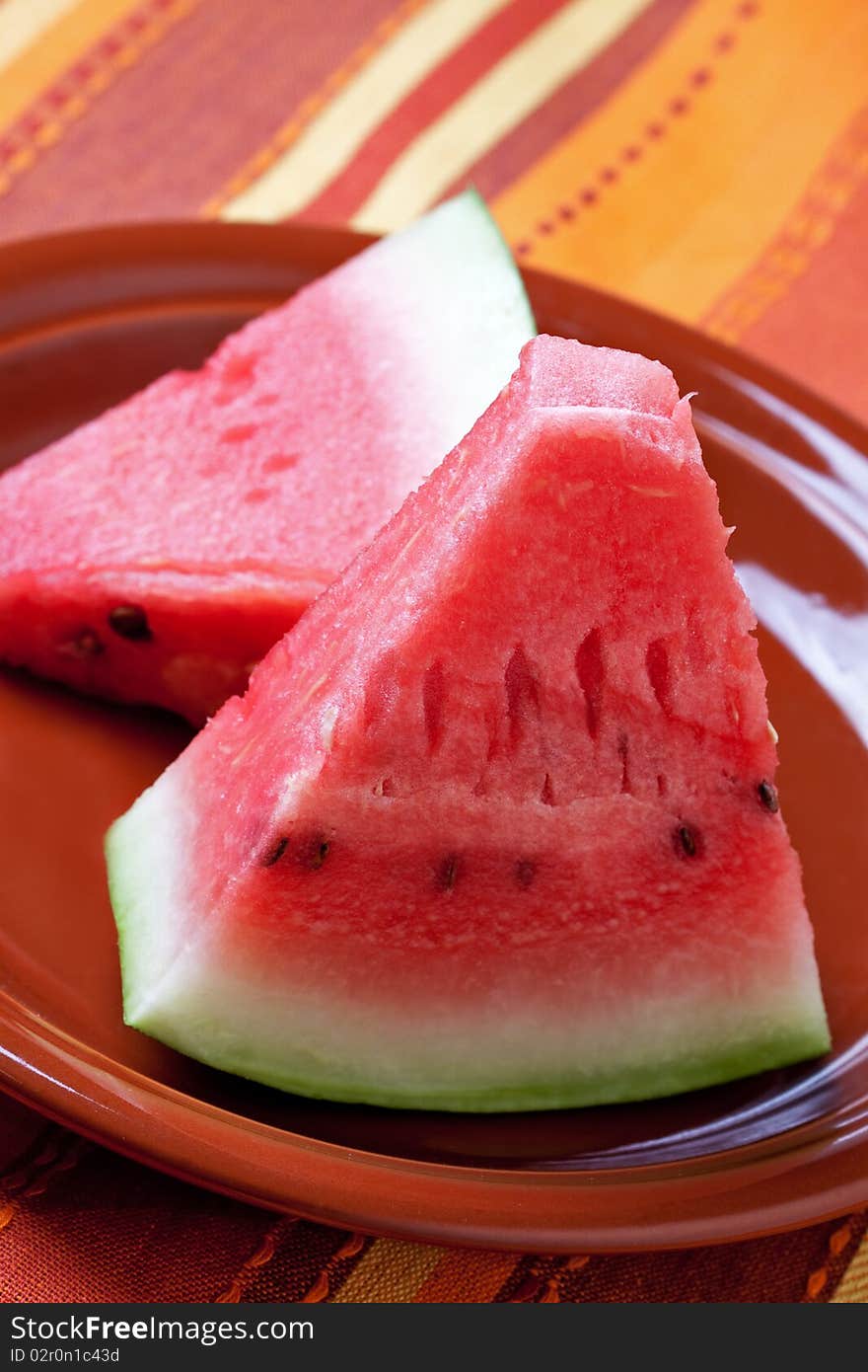 Fresh watermelon slices on brown plate