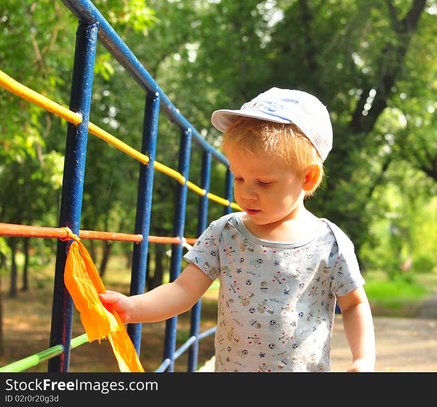 A little boy watches a red bow on the bridge. A little boy watches a red bow on the bridge