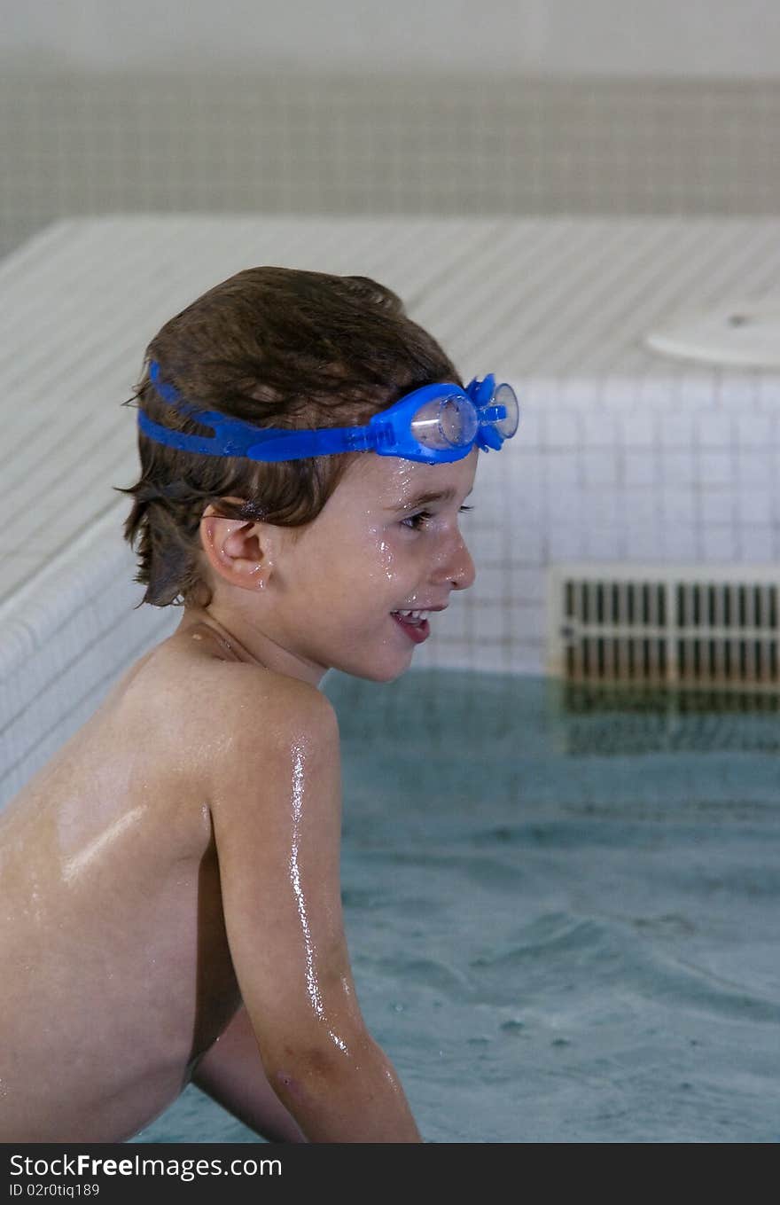 A boy taking a swim lesson at an indoor pool. A boy taking a swim lesson at an indoor pool