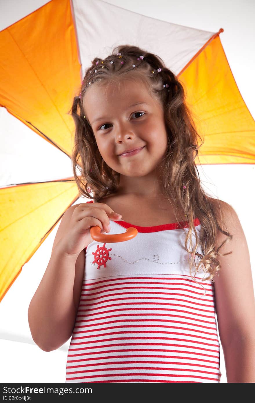 Little girl wearing summer dress and holding umbrella, studio shot