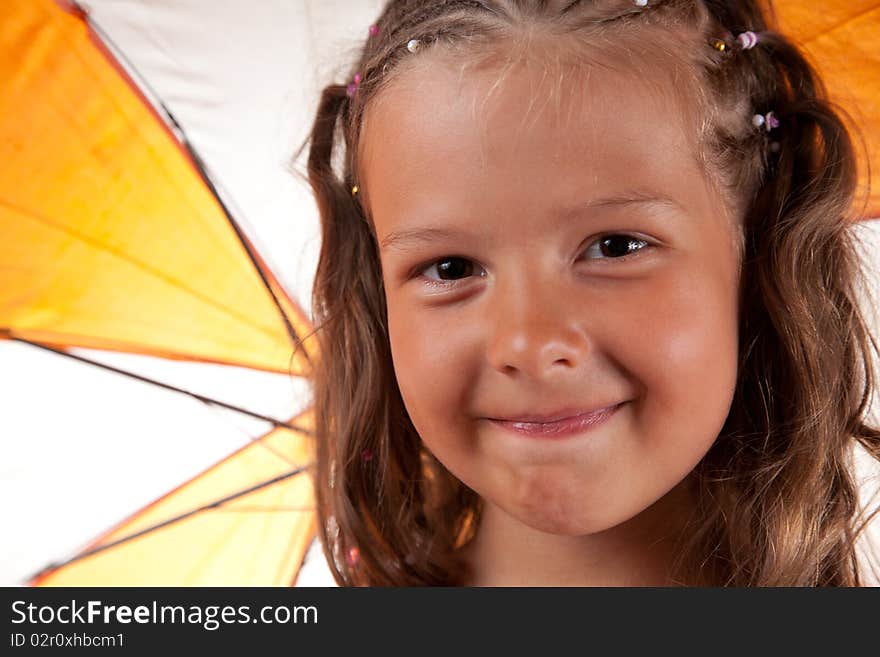 Close-up shot of cute little girl with orange umbrella