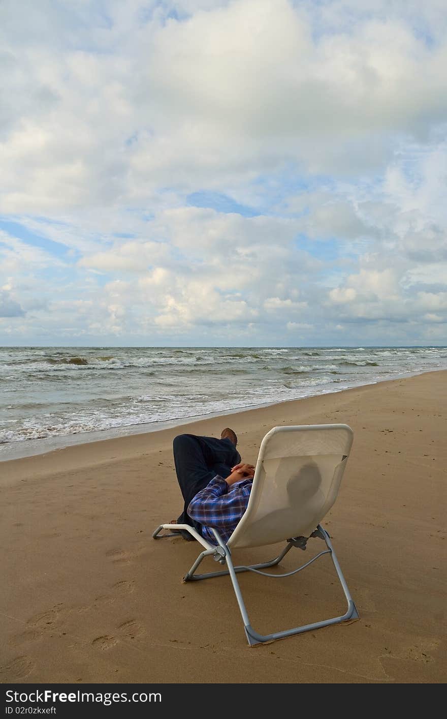 Man sitting in chair on the beach. Man sitting in chair on the beach.