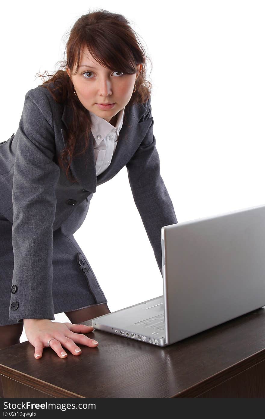 Young businesswoman working on laptop computer at desk, isolated on white background