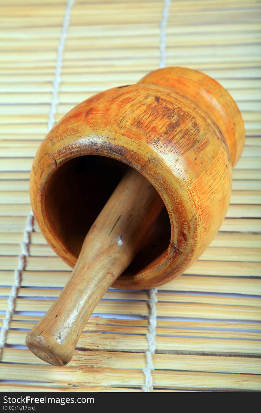 Wooden mortar and pestle with wooden background.