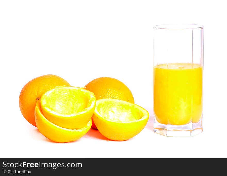 Glass of fresh orange juice with oranges lying nearby