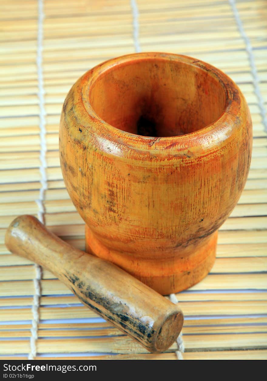 Wooden mortar and pestle with wooden background.