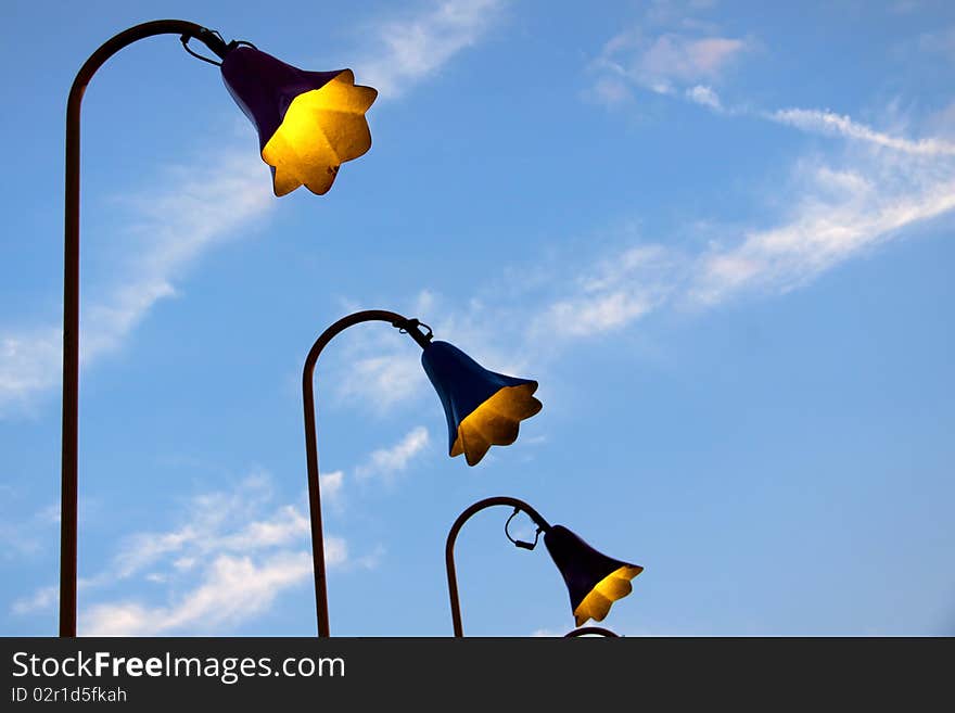 Many antique lamp posts in a row against blue sky. Many antique lamp posts in a row against blue sky