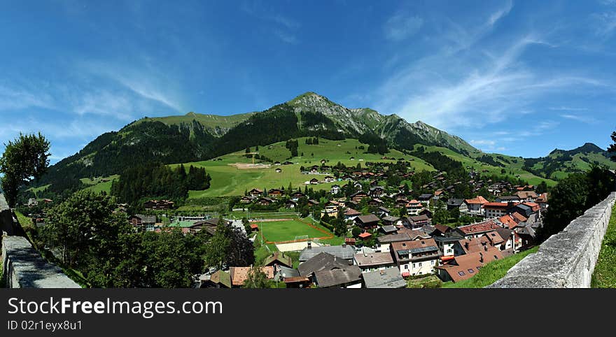 Panorama image taken above the town of Chateau d'Oex, Vaud canton, Switzerland. Typical Swiss country houses and the beautiful Swiss Alps can be seen in the back. Panorama image taken above the town of Chateau d'Oex, Vaud canton, Switzerland. Typical Swiss country houses and the beautiful Swiss Alps can be seen in the back.