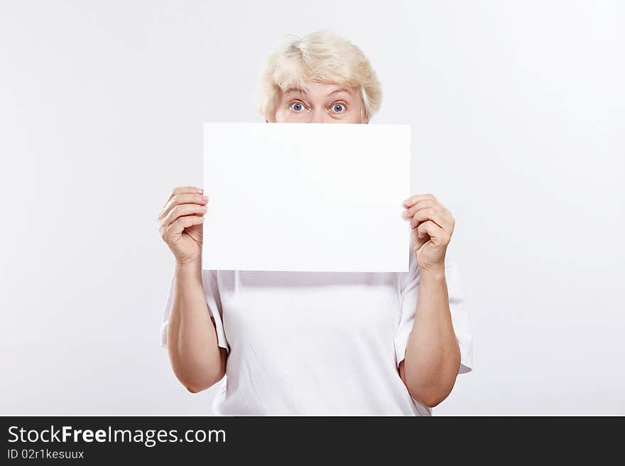 Mature woman with surprised eyes with a blank form. Mature woman with surprised eyes with a blank form