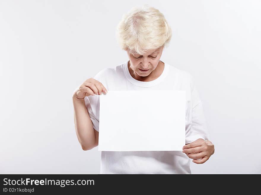 Mature woman looking at a blank form on a white background. Mature woman looking at a blank form on a white background