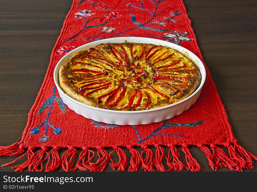 Home-made paprika pie on the red linen and wenge colour table