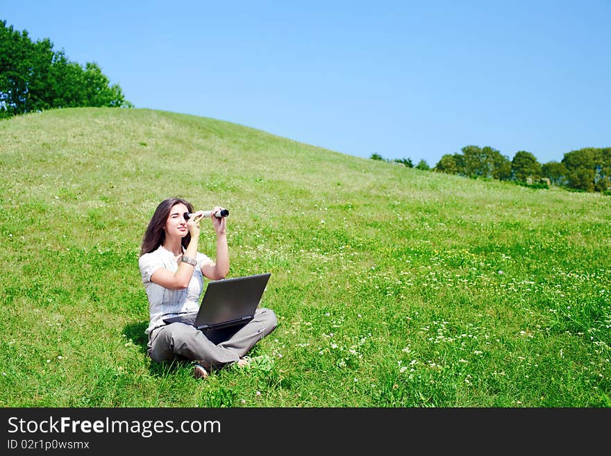 Woman with spyglass and notebook on grass