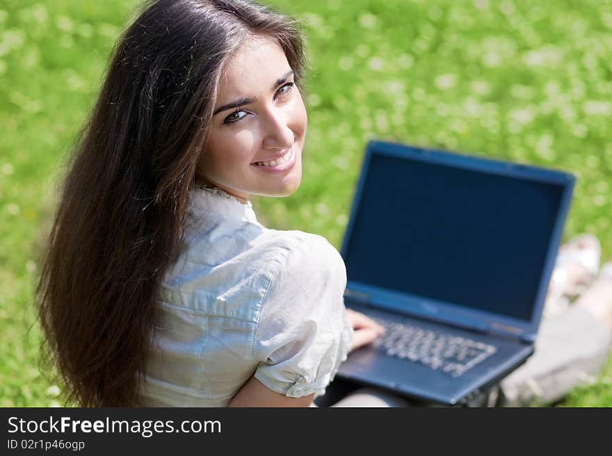 Young woman with notebook on grass