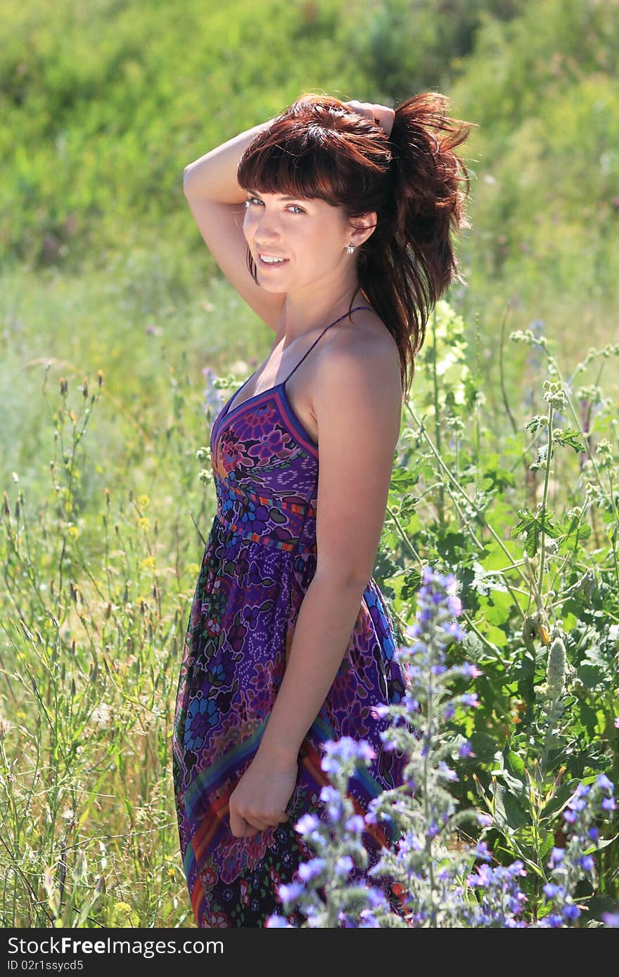 Brunette girl in the summer field in the sunny day