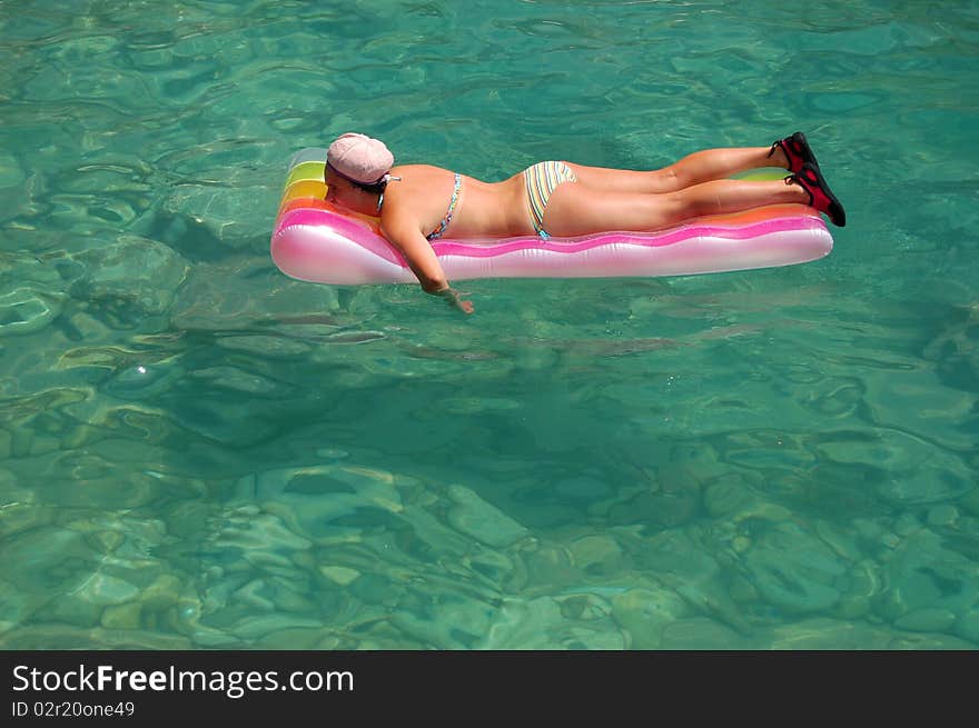 A girl sunbathing on a mattress