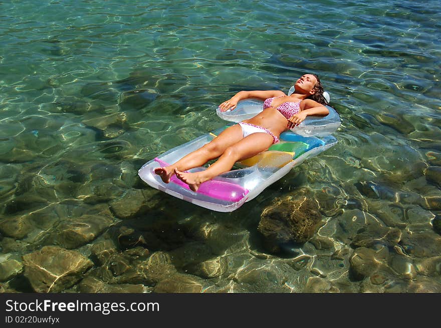 A girl on a mattress in Adriatic waters of Montenegro. A girl on a mattress in Adriatic waters of Montenegro