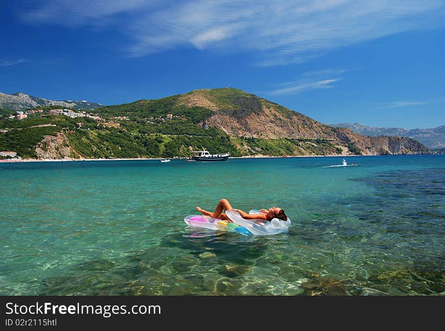 A girl sunbathing on a mattress in Adriatic waters in Montenegro