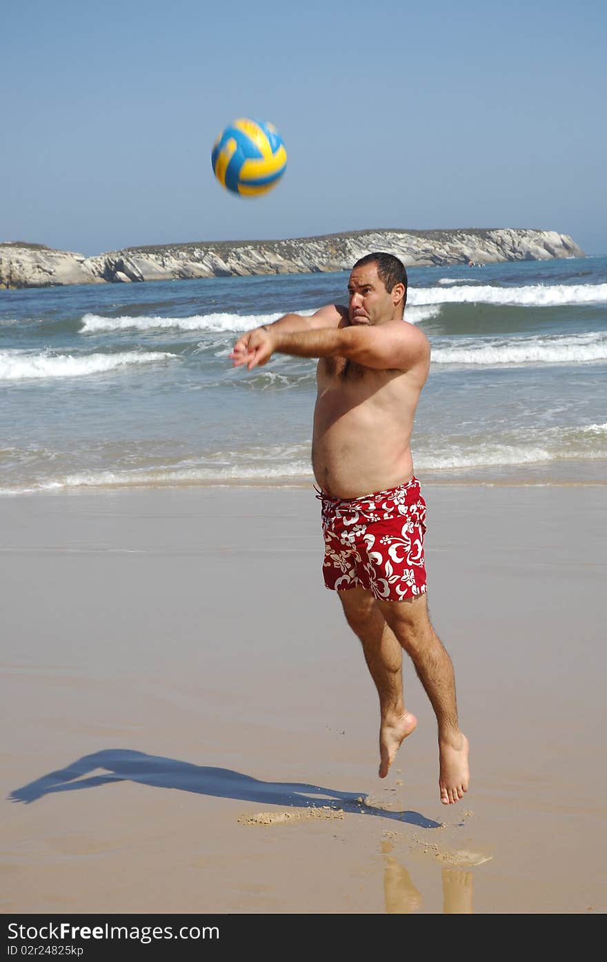 Fat Man Playing With A Ball On The Beach