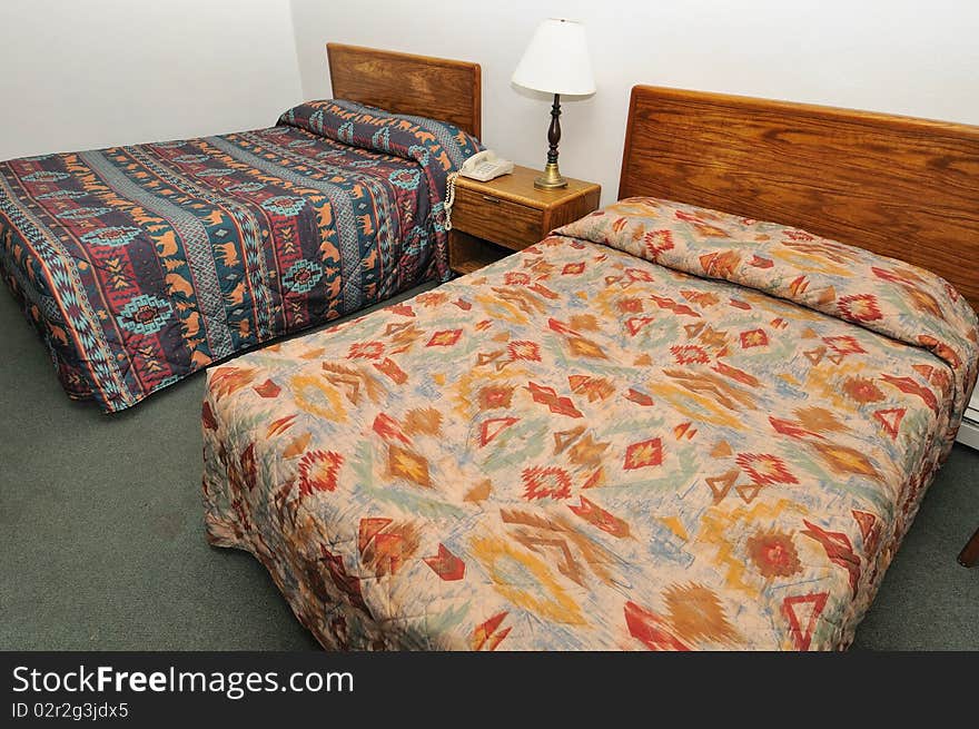 Double queen size beds in a simple hotel room. For architecture, tourism, travel and backpacking concepts. Double queen size beds in a simple hotel room. For architecture, tourism, travel and backpacking concepts