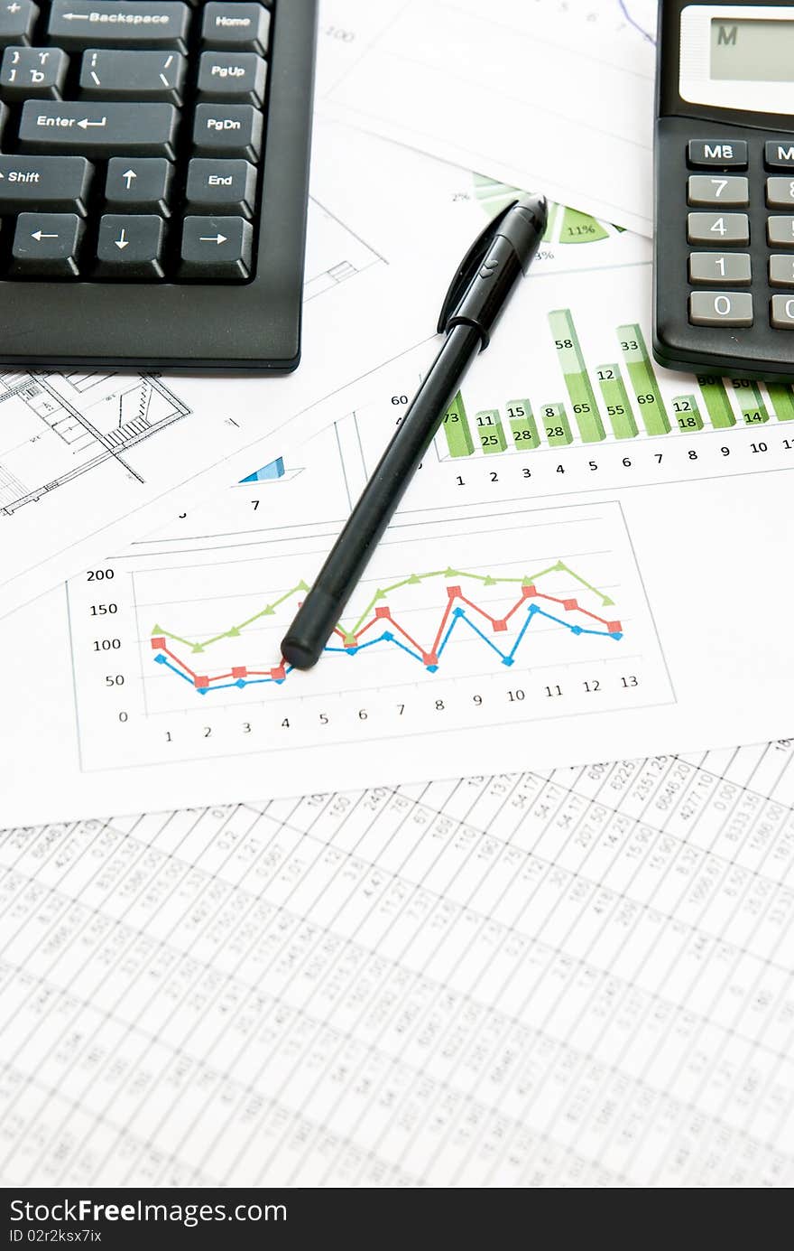 Business still-life with diagrams, pen and calculator