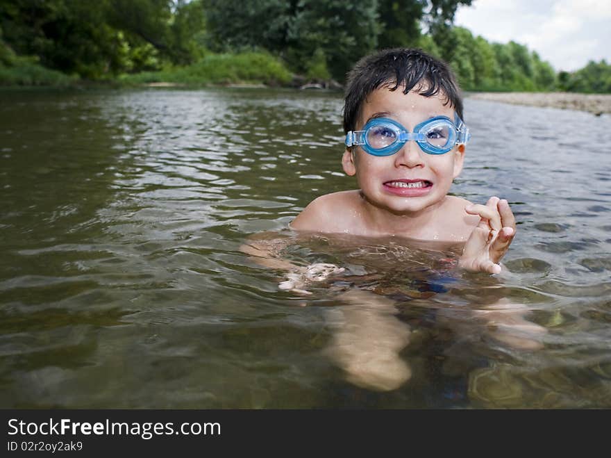 Boy in goggles in creek