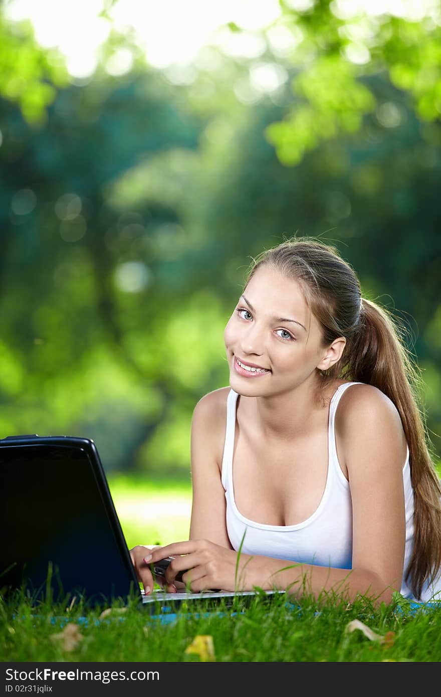 Young girl with laptop in the park