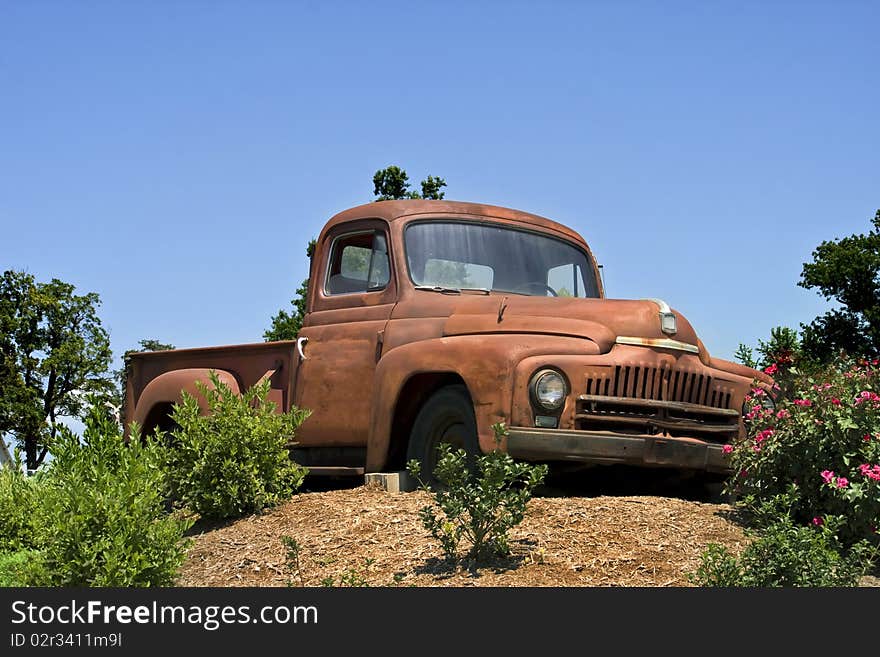 Old rusty antique truck parked on a hill with blue sky in background. Old rusty antique truck parked on a hill with blue sky in background