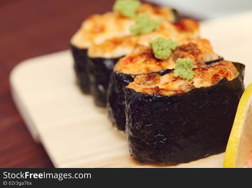 Sushi and rolls on the wooden plate close-up