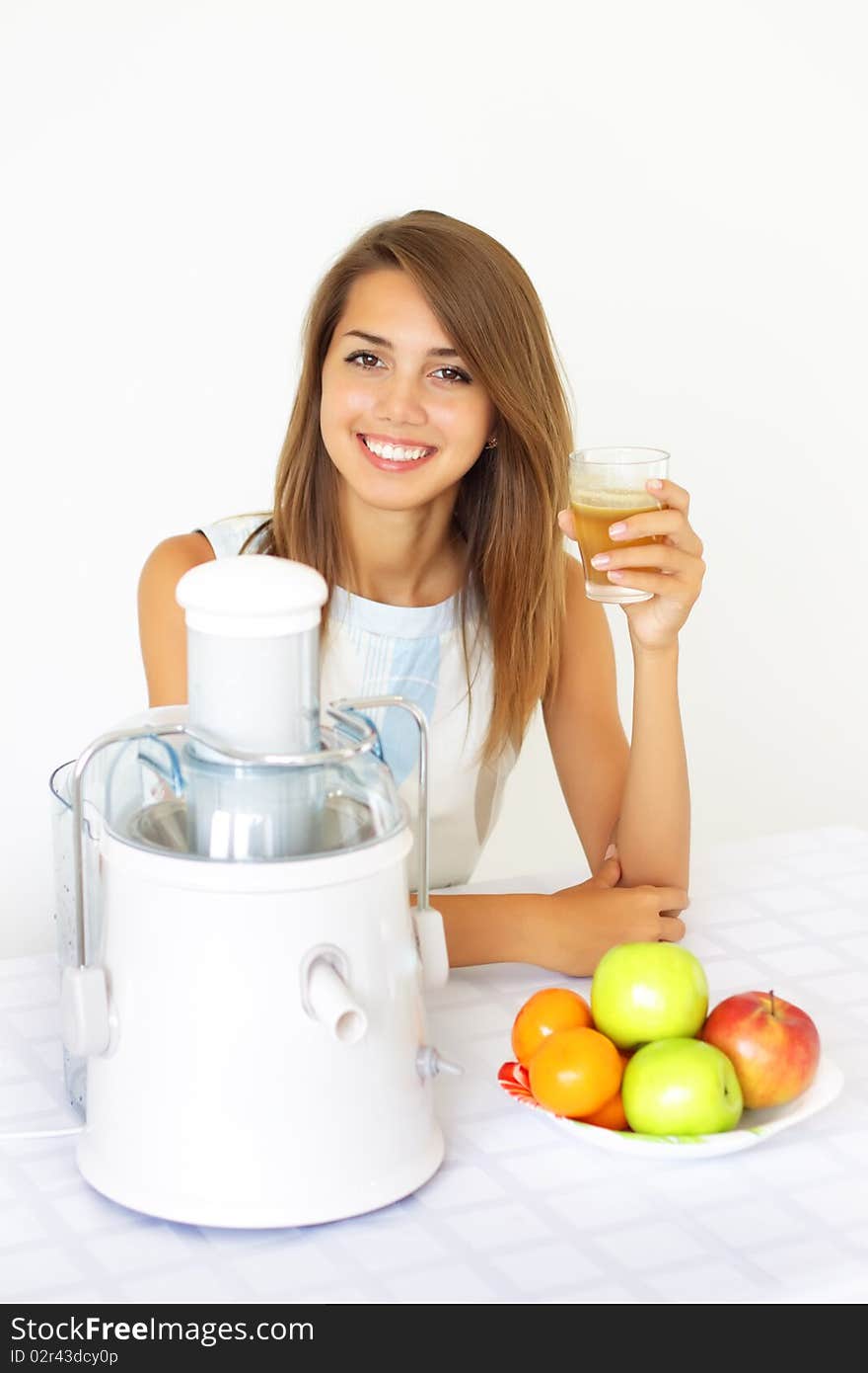 Happy girl about juicers on a light background