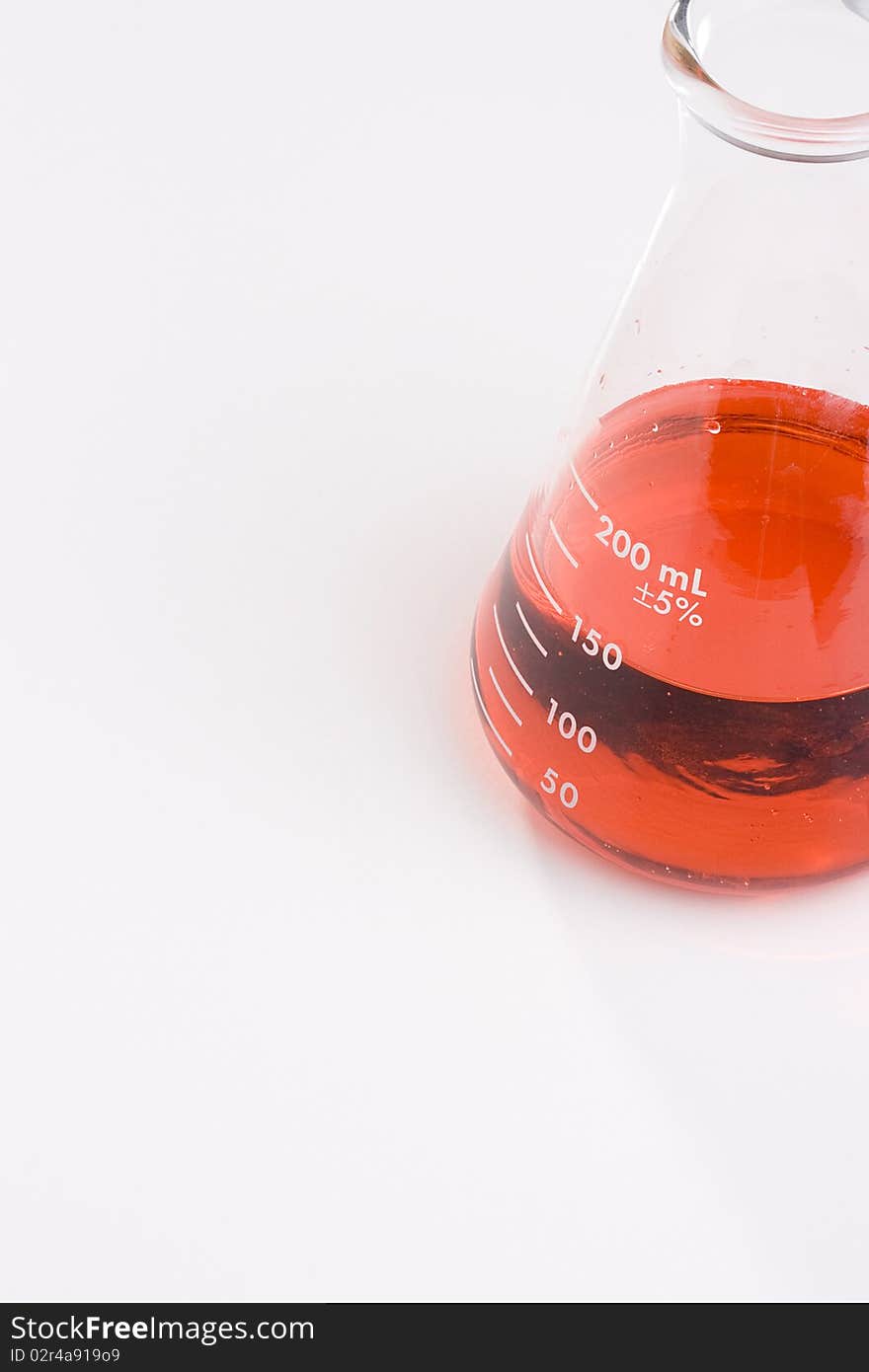 An erlenmeyer flask with red liquid on a white background. Add your text to the background.