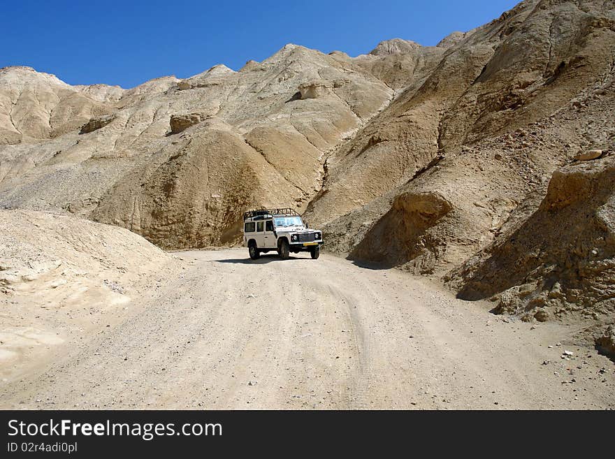 Lonely jeep among mountains in desert. Lonely jeep among mountains in desert