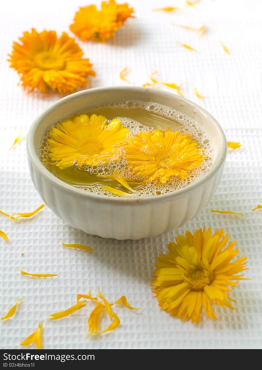 Bowl of water and flowers . Chamomile on background. Could be a generic toiletry.