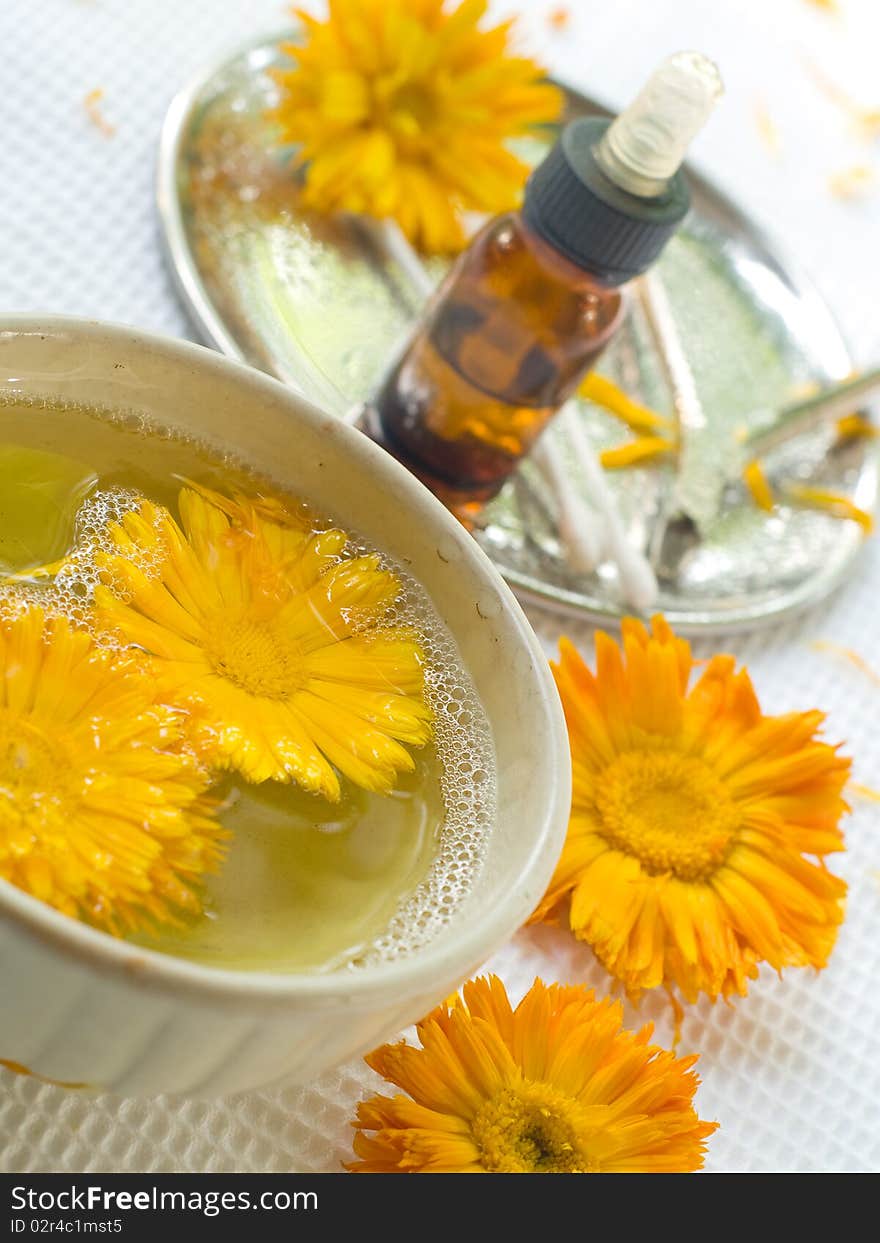 Bowl of water with yellow flower. Device for manicure on background. Could be a generic toiletry. Bowl of water with yellow flower. Device for manicure on background. Could be a generic toiletry.