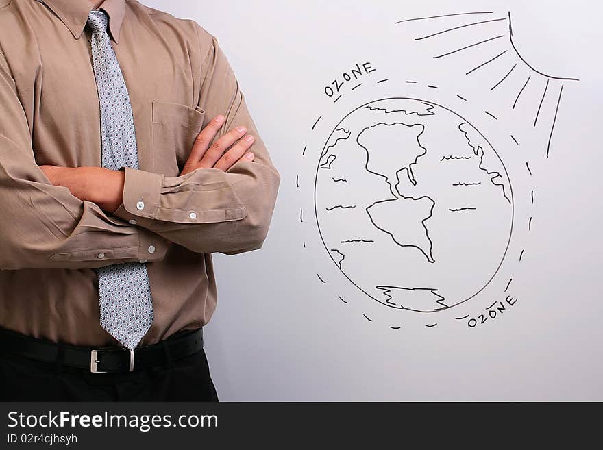 Man in a shirt and a tie standing with his arms crossed next to a drawing of the earth's ozone layer. Man in a shirt and a tie standing with his arms crossed next to a drawing of the earth's ozone layer.