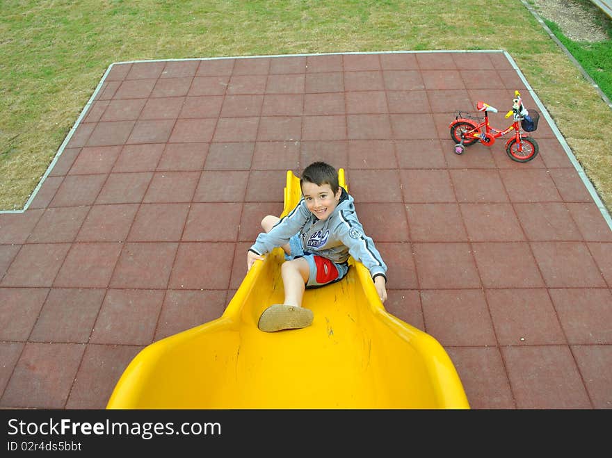 Boy sliding on the yellow slide. Boy sliding on the yellow slide