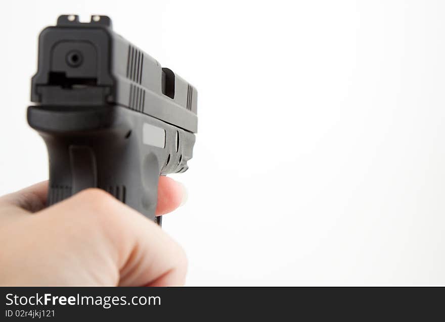 Female hand pointing gun toward white background. Female hand pointing gun toward white background