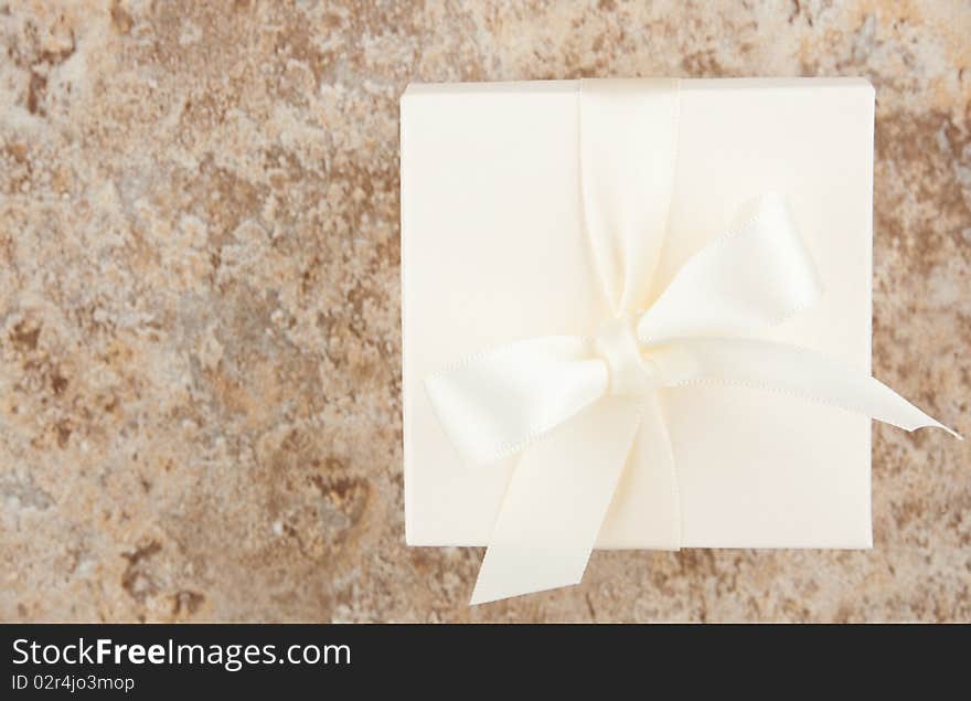 Cream colored favor box against variegated neutral background