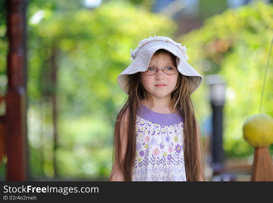 Toddler Girl In Sun Hat On The Green Background