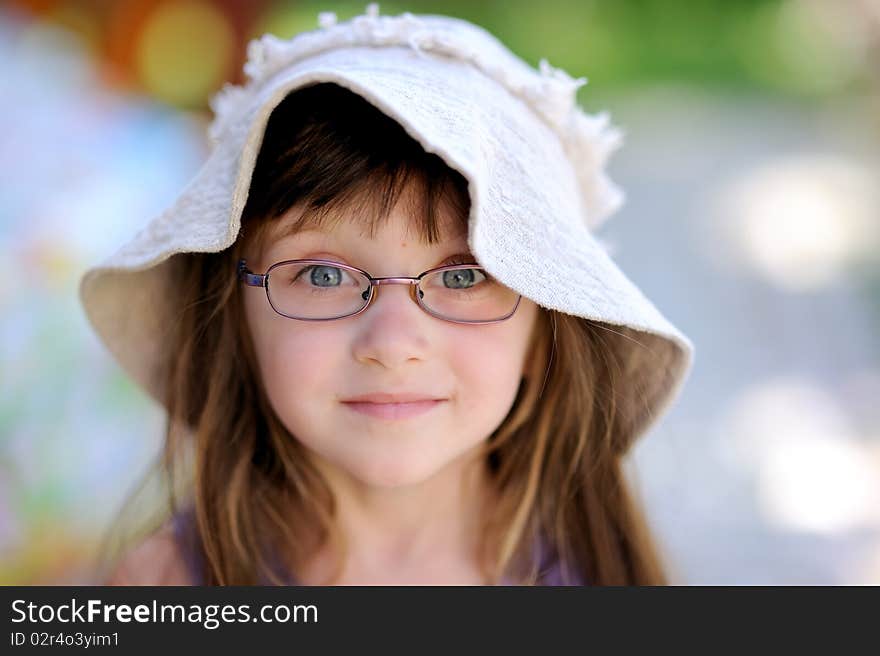 Nice toddler girl in sun hat on the green background