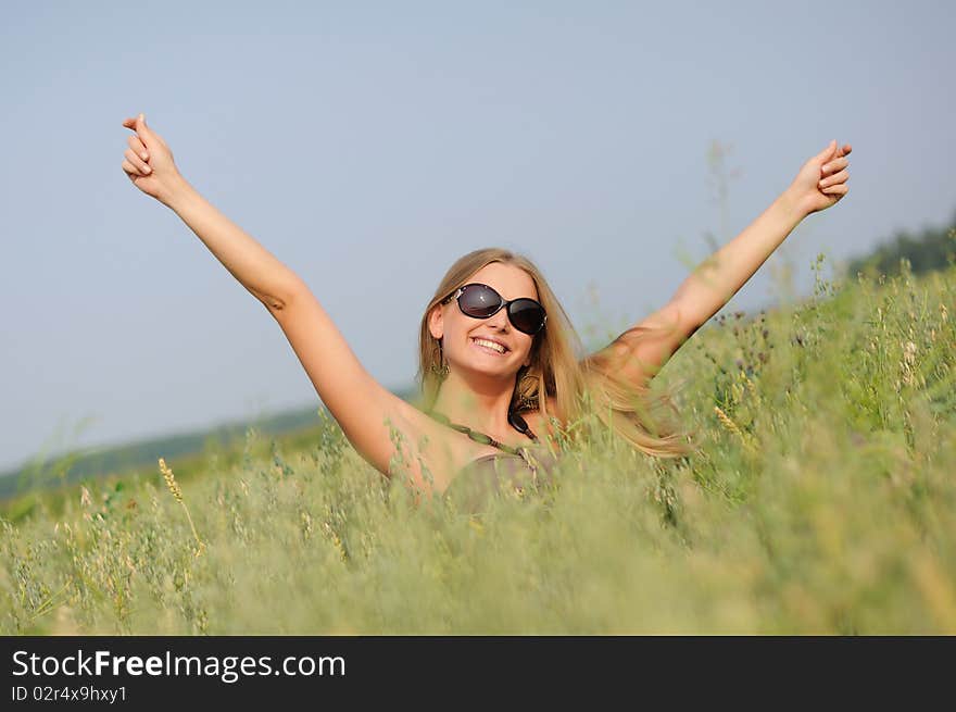 Young woman with glasses in the field happy and laughing.