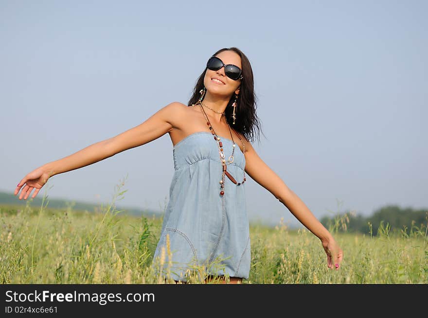 Young woman with glasses in the field happy and laughing.