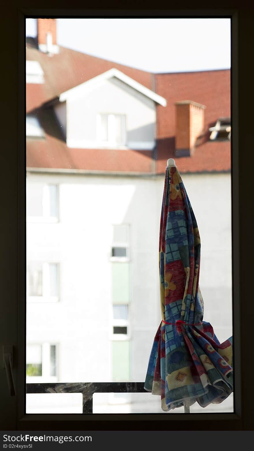 White window frame with view at opposite building and with parasol. White window frame with view at opposite building and with parasol