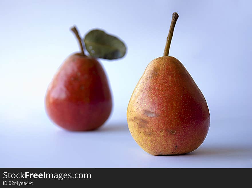 Two tasty pear on a blue background, one blured and one focused. Two tasty pear on a blue background, one blured and one focused