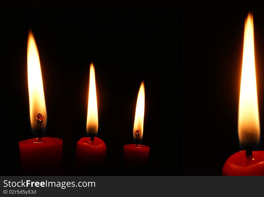 Four red candles on black background