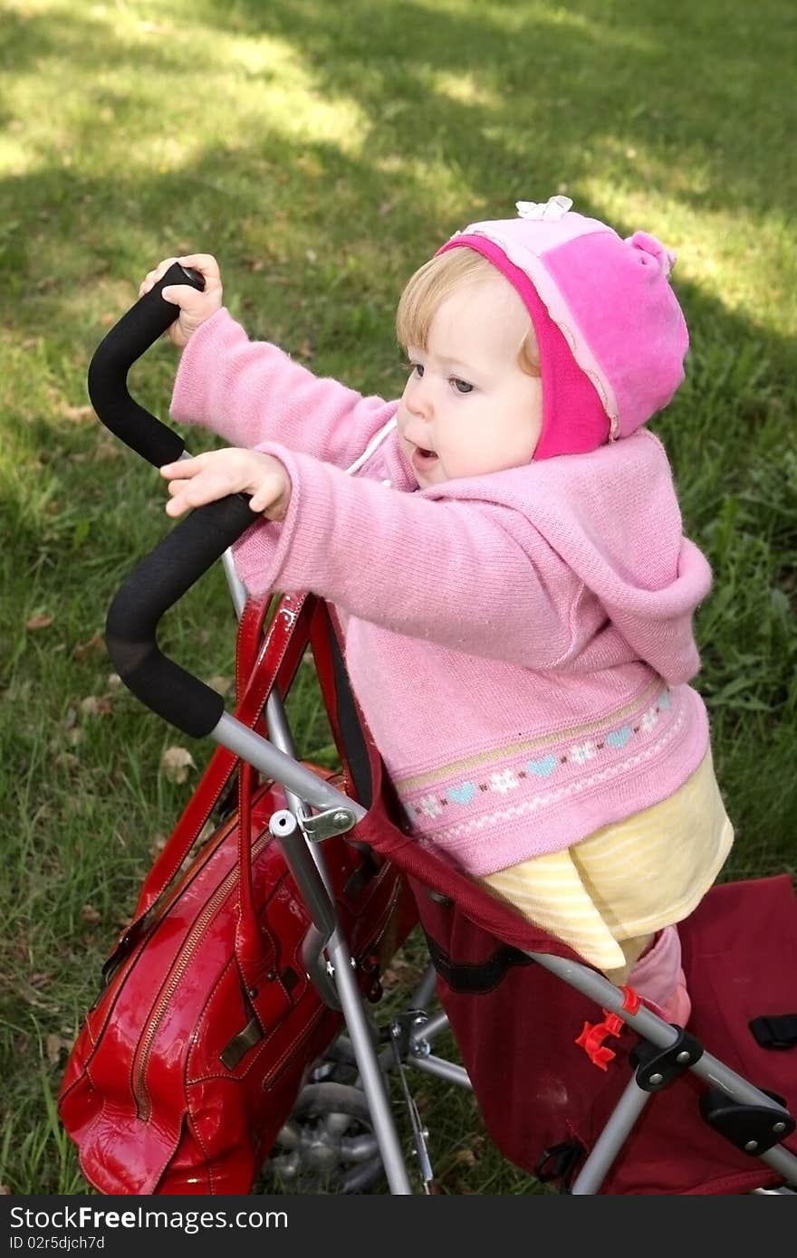 A little girl is in the stroller. A little girl is in the stroller