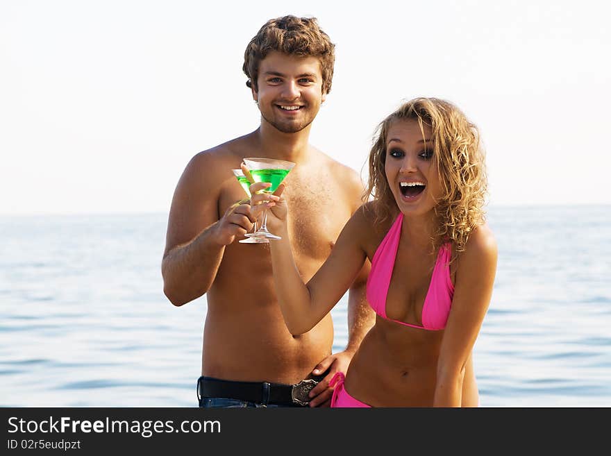 Young couple on the seaside with cocktails