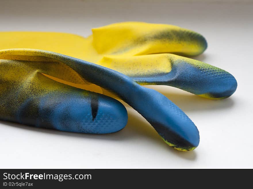 Colored rubber gloves on white ground.