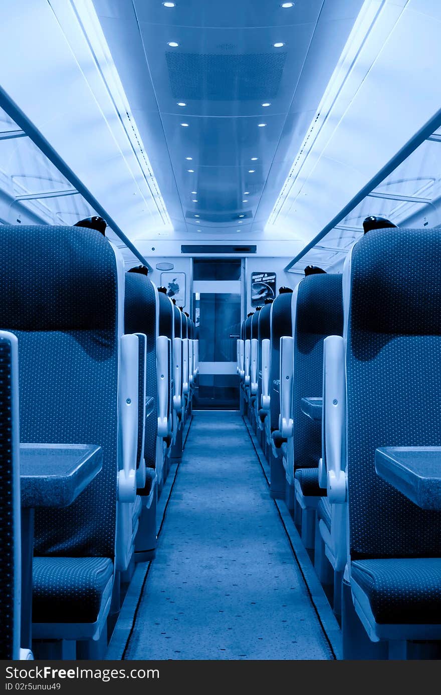 Modern railway coach interior illuminated and row of seats, monochromatic. Modern railway coach interior illuminated and row of seats, monochromatic